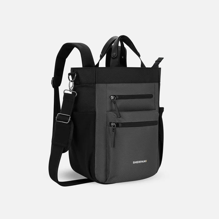 A Sherpani Soleil Granite Anti-theft Multi-Wear Travel Bag, 3/4 view showing lockable pockets and straps on white backdrop. #color_granite-grey