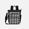 A Sherpani Soleil Houndstooth Anti-theft Multi-Wear Travel Bag, front view showing lockable pockets on white backdrop. #color_houndstooth-print