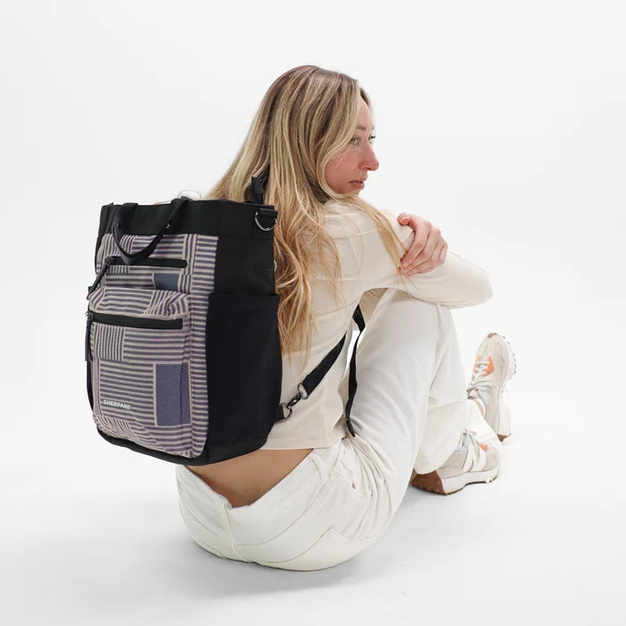 Woman holding Sherpani Soleil Passport Anti-theft Multi-Wear Travel Bag by backpack straps on white backdrop. #color_passport-print
