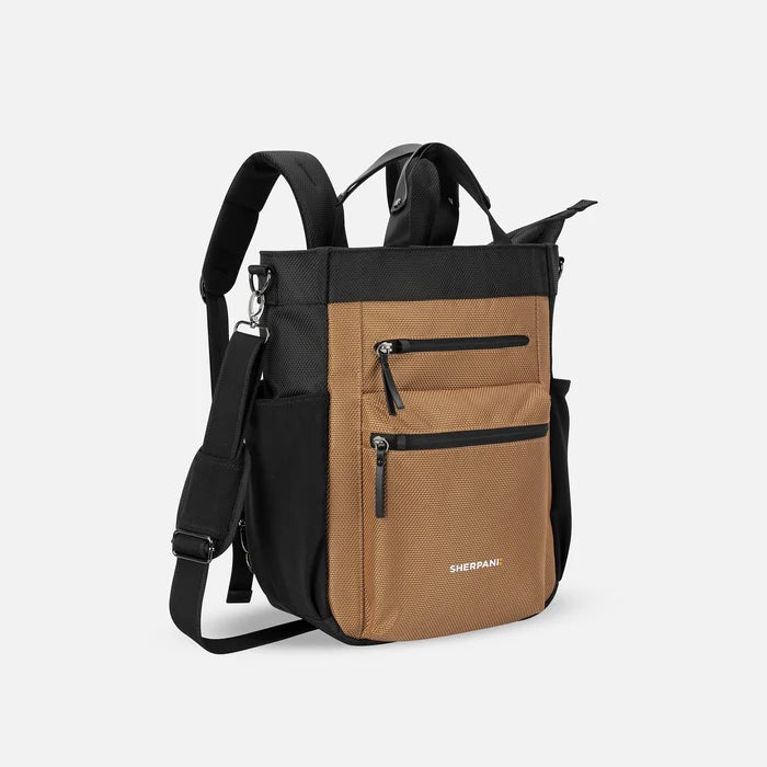 A Sherpani Soleil Sand Anti-theft Multi-Wear Travel Bag, 3/4 view showing lockable pockets and straps on white backdrop. #color_sand-tan
