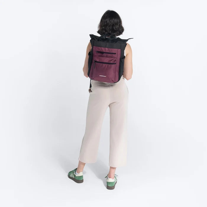 Woman holding Sherpani Soleil Smoky Orchid Anti-theft Multi-Wear Travel Bag by backpack straps on white backdrop. #color_smoky-orchid-pink