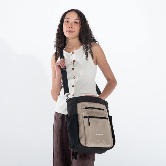 Woman wearing Sherpani Soleil Straw Beige Anti-theft Multi-Wear Travel Bag on her shoulder against white backdrop.  #color_straw-beige