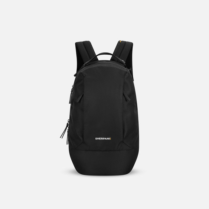 A Sherpani Solstice Carbon Black Anti-Theft Travel Backpack, front view showing front pockets and different straps on white background.  #color_carbon-black