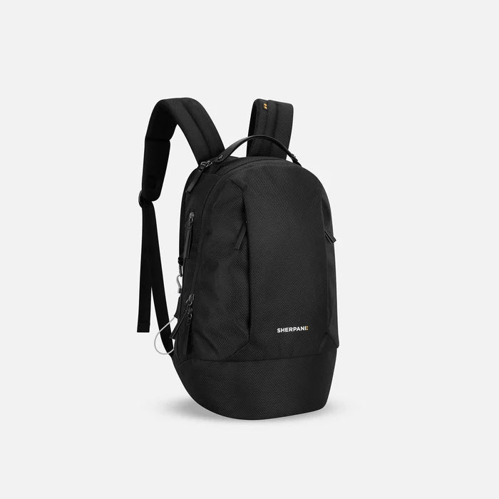 A Sherpani Solstice Carbon Black Anti-Theft Travel Backpack, 3/4 view showing back strap pockets and different strap options against a white background. #color_carbon-black