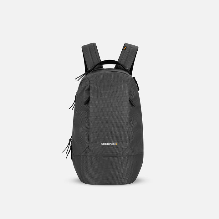 A Sherpani Solstice Granite Grey Anti-Theft Travel Backpack, front view showing front pockets and different straps on white background.  #color_granite-grey