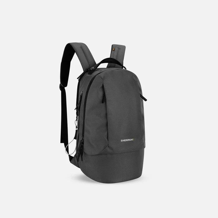 A Sherpani Solstice Granite Anti-Theft Travel Backpack, 3/4 view showing back strap pockets and different strap options against a white background.  #color_granite-grey