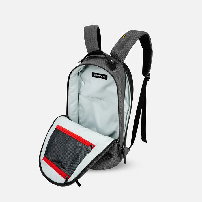A Sherpani Solstice Granite Anti-Theft Travel Backpack, 3/4 view showing the inside of the main and side pocket against a white background.  #color_granite-grey