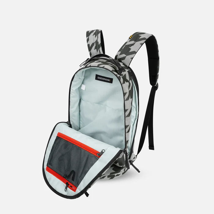 A Sherpani Solstice Houndstooth Anti-Theft Travel Backpack, 3/4 view showing the inside of the main and side pocket against a white background.  #color_houndstooth-print
