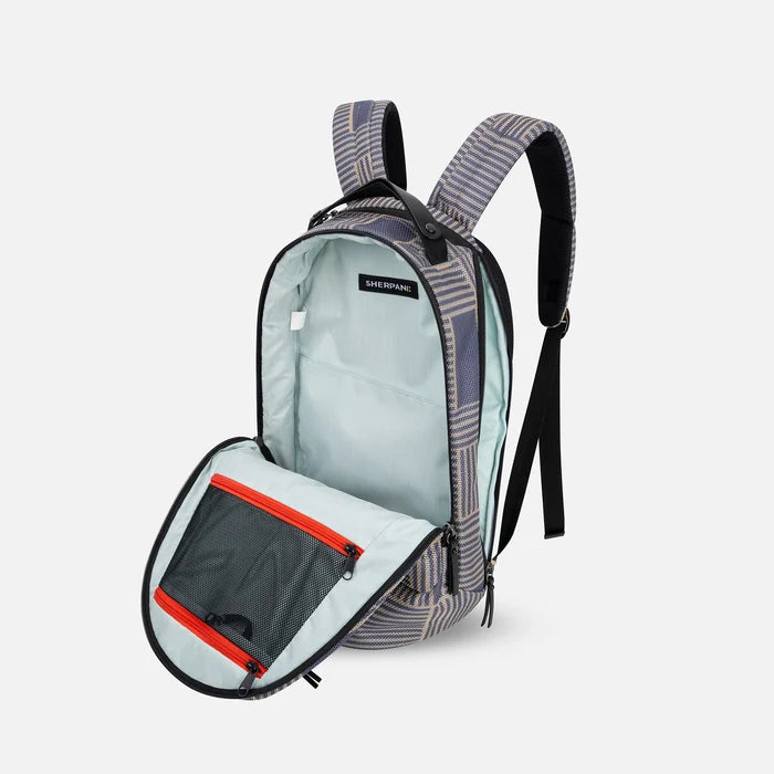 A Sherpani Solstice Passport Anti-Theft Travel Backpack, 3/4 view showing the inside of the main and side pocket against a white background.  #color_passport-print