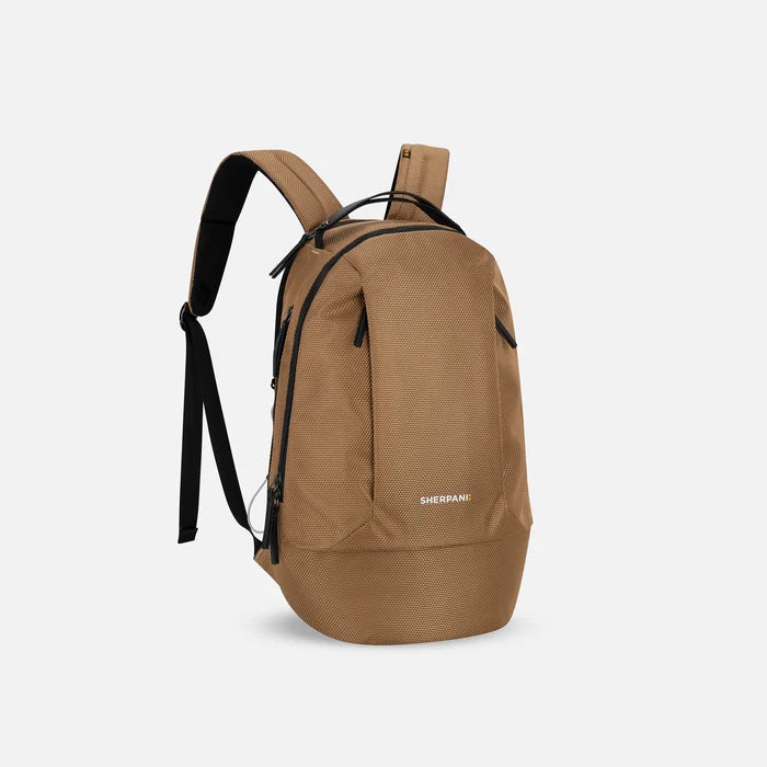 A Sherpani Solstice Sand Tan Anti-Theft Travel Backpack, 3/4 view showing back strap pockets and different strap options against a white background. #color_sand-tan