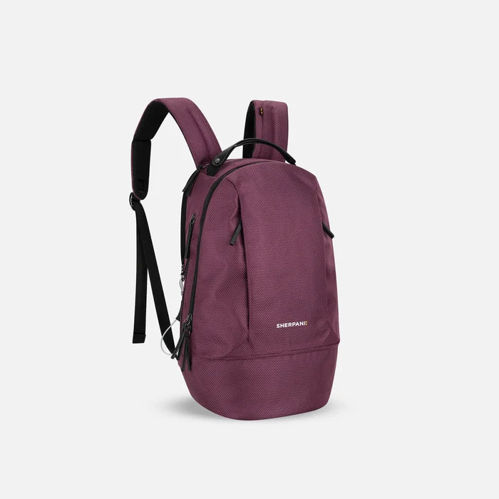 A Sherpani Solstice Smoky Orchid Anti-Theft Travel Backpack, 3/4 view showing back strap pockets and different strap options against a white background.  #color_smoky-orchid-pink