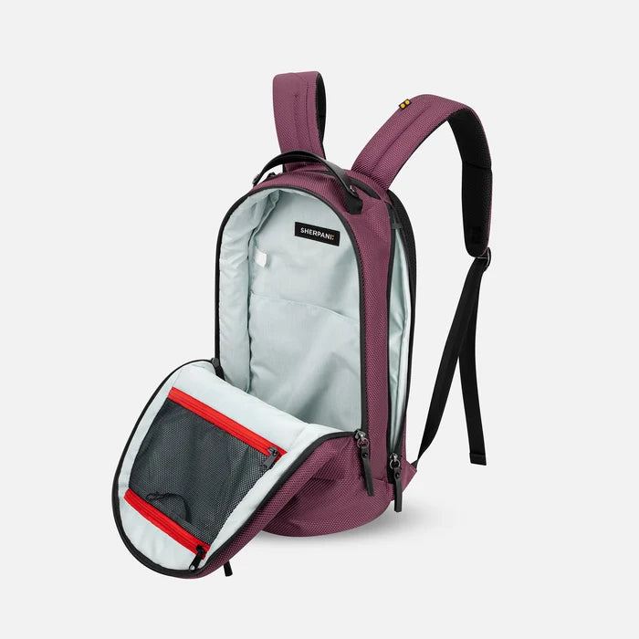 A Sherpani Solstice Smoky Orchid Anti-Theft Travel Backpack, 3/4 view showing the inside of the main and side pocket against a white background.  #color_smoky-orchid-pink