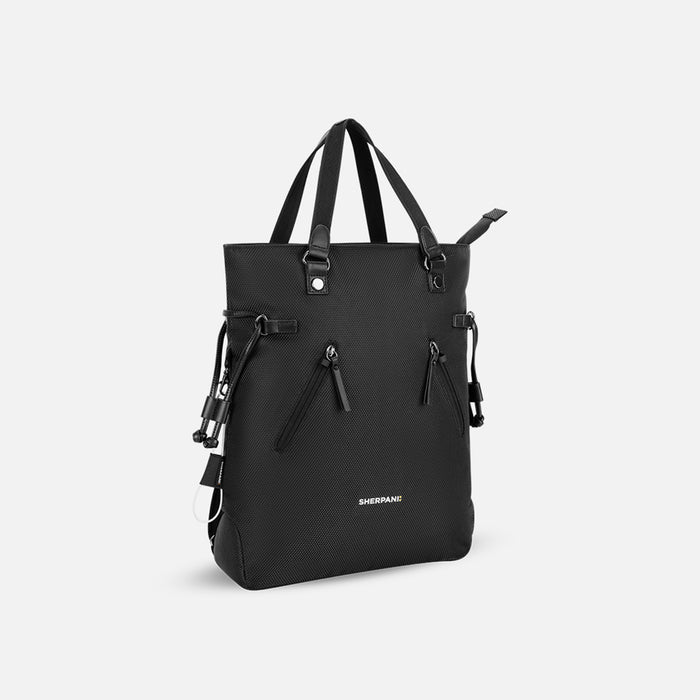 A Sherpani Tempest Carbon Black Convertible Tote, 3/4 view showing tote straps & front lockable pockets on white backdrop.  #color_carbon-black