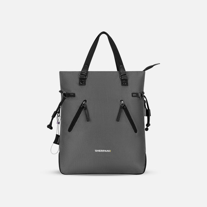 A Sherpani Tempest Granite Grey Convertible Tote, front view showing tote straps & front lockable pocket on white background. #color_granite-grey