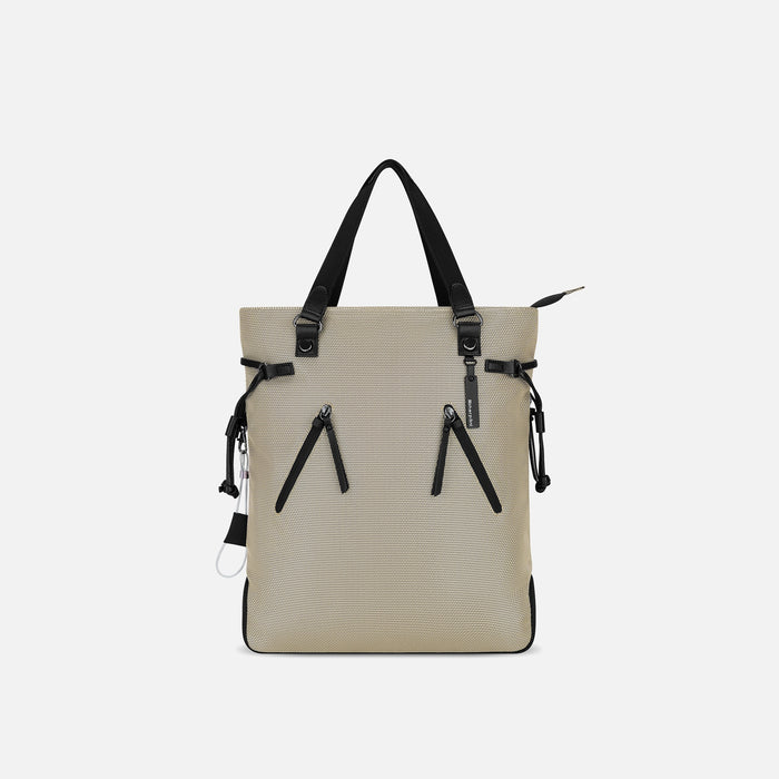A Sherpani Tempest Straw Beige Convertible Tote, front view showing lockable pockets & straps against white background. #color_straw