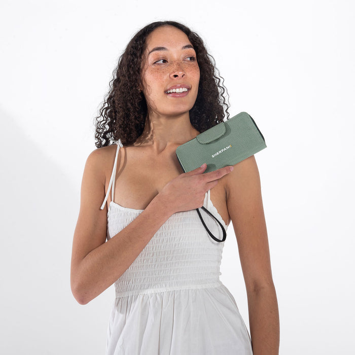 Woman holds a Sherpani Tulum Aloe Mist Green Anti-theft RFID Wallet against white background.  #color_aloe-mist-green