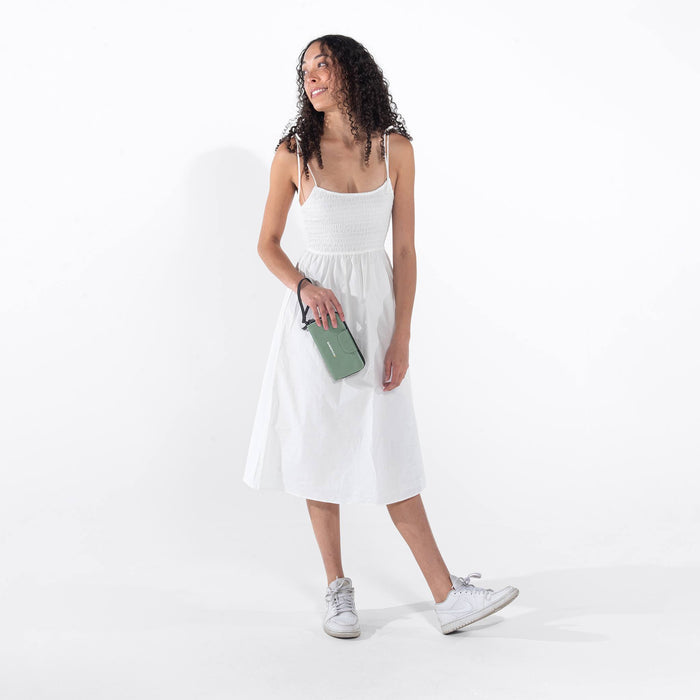 Woman holding a Sherpani Tulum Aloe Mist Green Anti-theft RFID Wallet against white background.  #color_aloe-mist-green