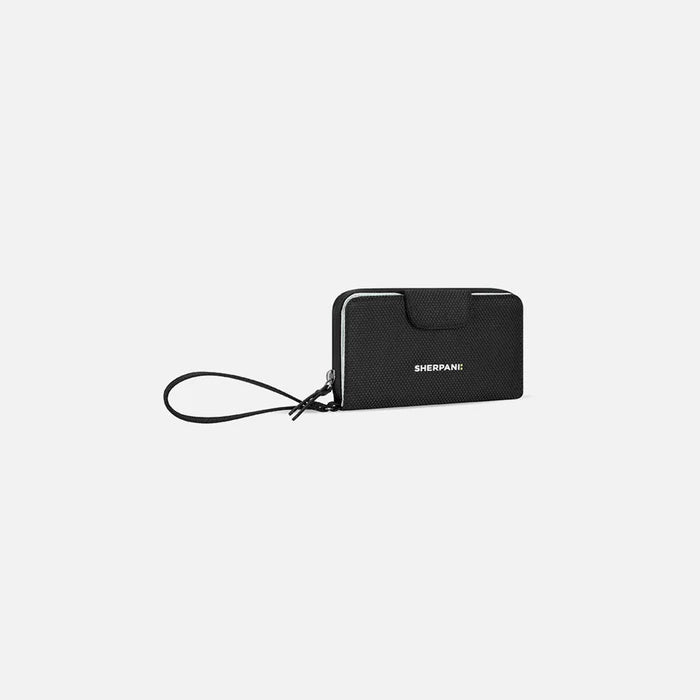 A Sherpani Tulum Carbon Black Anti-Theft Wallet, 3/4 view showing wrist strap and clasp on white background. #color_carbon-black