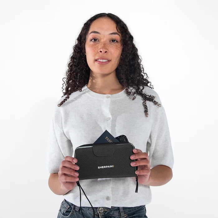 Woman holding a Sherpani Tulum houndstooth Anti-Theft Wallet against white background.  #color_carbon-black