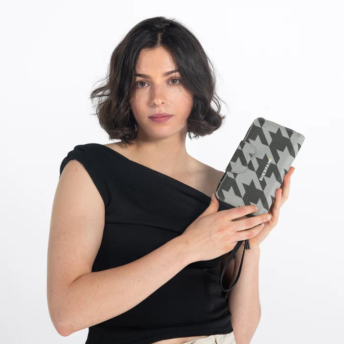 Woman holding a Sherpani Tulum houndstooth Anti-Theft Wallet against white background.  #color_houndstooth-print