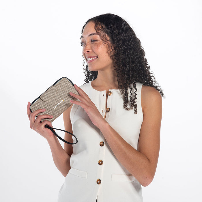 Woman holds a Sherpani Tulum Straw Beige Anti-theft RFID Wallet against white background.  #color_straw-beige