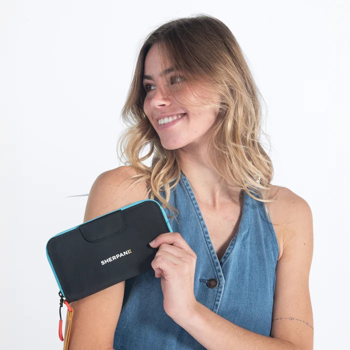 Woman holding a Sherpani Tulum Chromatic Black RFID Wallet against white background.   #color_chromatic-black