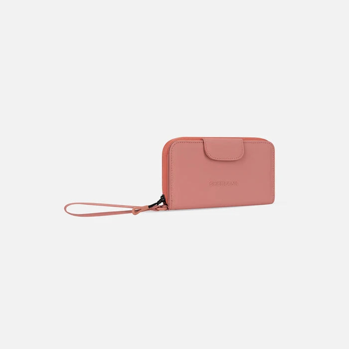 A Sherpani Tulum Desert Pink RFID Wallet, 3/4 view showing wrist strap and clasp on white background.  #color_desert-pink