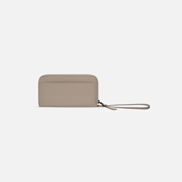 A Sherpani Tulum Dune RFID Wallet, back view showing wrist strap on white background. #color_dune-tan
