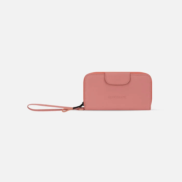 A Sherpani Tulum Desert Pink RFID Wallet, front view showing wrist strap and clasp on white background.#color_desert-pink