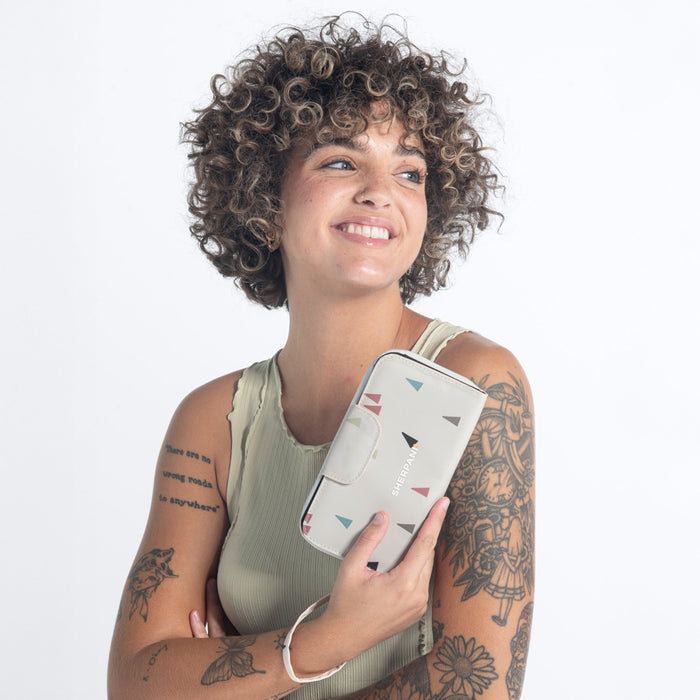 Woman holds a Sherpani Tulum Terrazzo Print RFID Wallet against white background.  #color_terrazzo-print