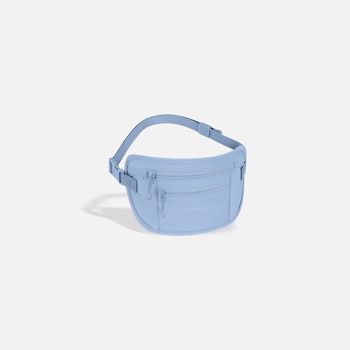 A Sherpani Soft Touch Concealed Waist Wallet Cool Blue, 3/4 view showing zipper pockets and strap on white background.