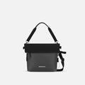 A Sherpani Vale Granite Anti-theft Reversible Crossbody, front view showing folded over front on white background.  #color_granite-grey