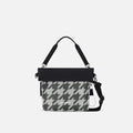 A Sherpani Vale Houndstooth Anti-theft Reversible Crossbody, front view showing folded over front on white background.  #color_houndstooth-print