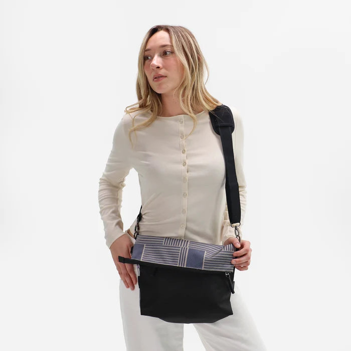 Woman wearing a Sherpani Vale Passport Anti-theft Reversible Crossbody against white background. #color_passport-print