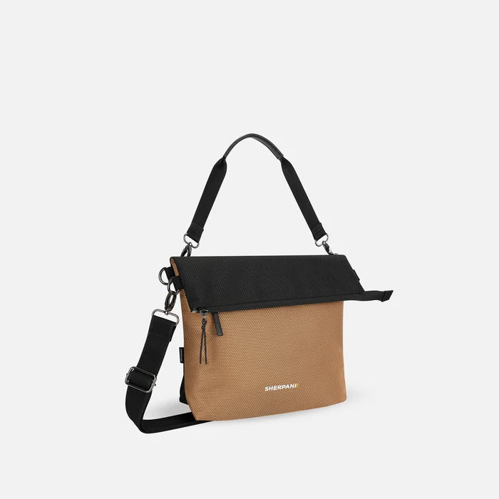 A Sherpani Vale Sand Anti-theft Reversible Crossbody, 3/4 view showing folded over front white background.  #color_sand-tan