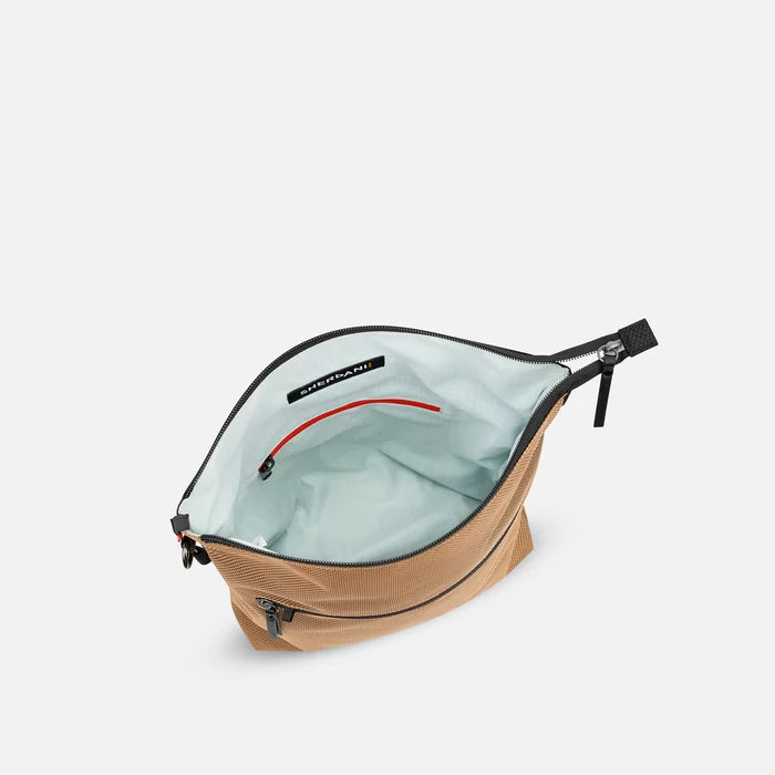 A Sherpani Vale Sand Anti-theft Reversible Crossbody, above view showing inside of main pocket on white background.  #color_sand-tan