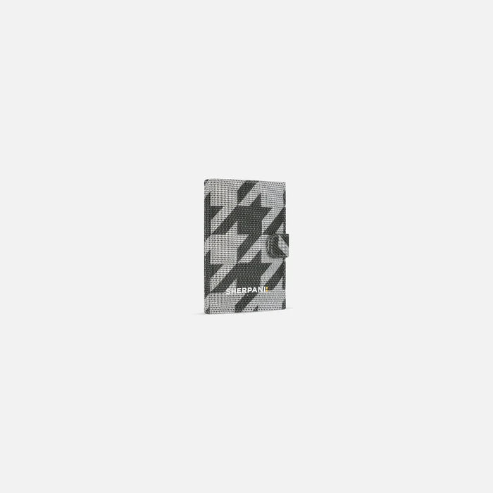 A Sherpani Vienna Houndstooth Anti-theft Passport Wallet, 3/4 view against white background.  #color_houndstooth-print