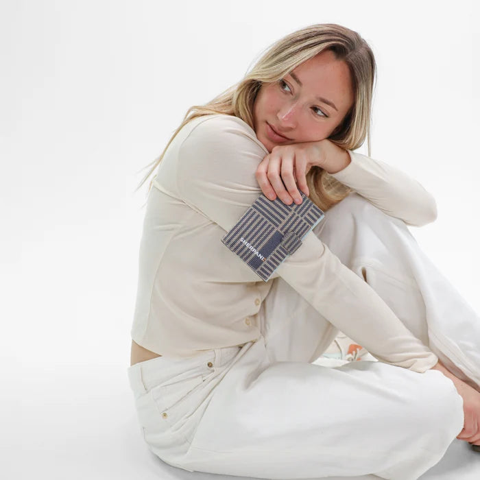 Woman holding a Sherpani Vienna Passport Anti-theft Passport Wallet against white background. #color_passport-print