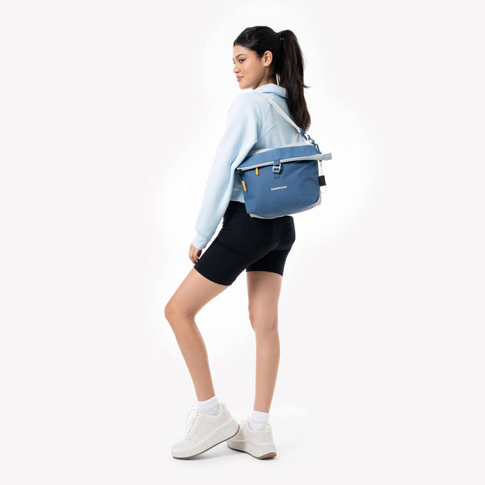 Woman wearing a Sherpani Viso Seastone Foldover Bag against a white backdrop. #color_seastone