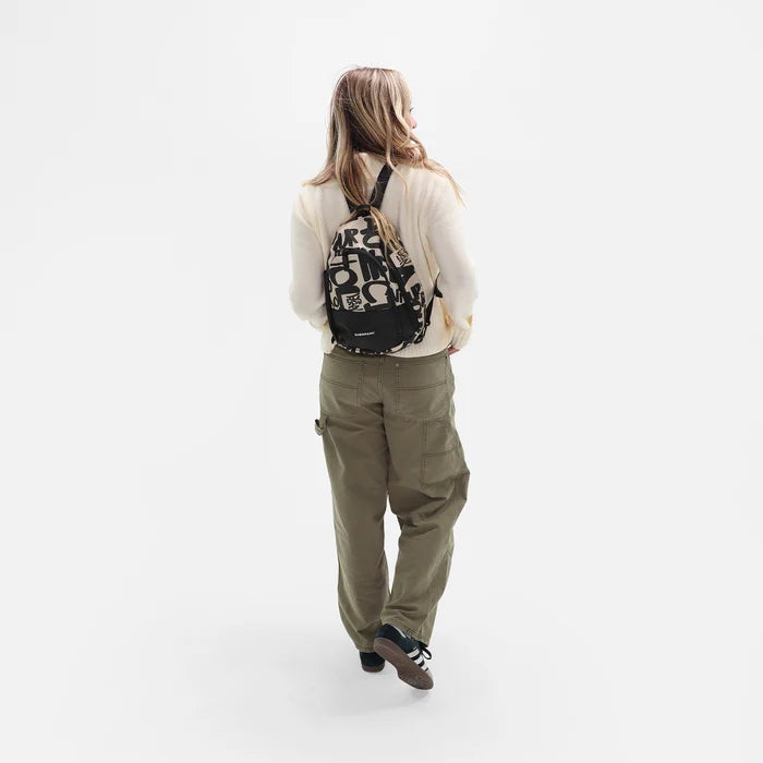 A woman wearing a Sherpani Wayfarer Ciao Convertible Sling on her back against white background.  #color_ciao-print