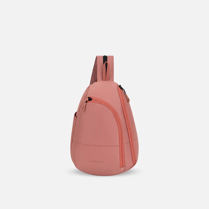 A Sherpani Wayfarer Desert Pink Convertible Sling, front view showing lockable pockets and main strap on white background. #color_desert-pink