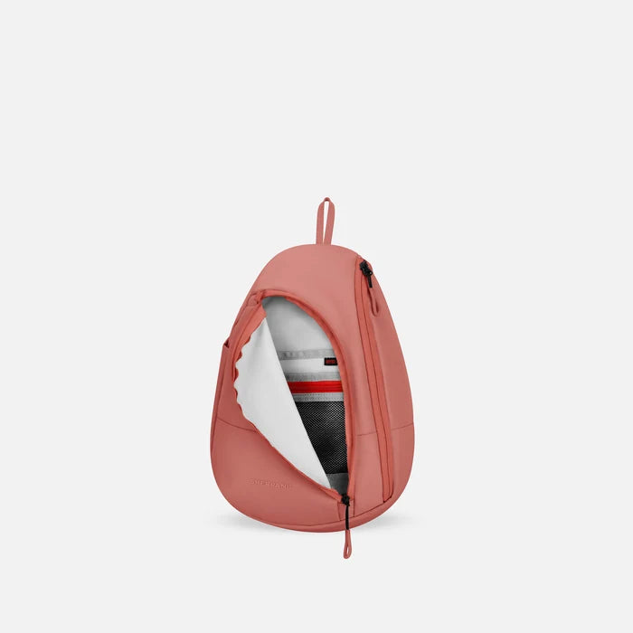 A Sherpani Wayfarer Desert Pink Convertible Sling, front view showing inside pocket against white background.   #color_desert-pink