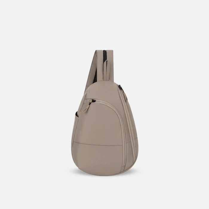A Sherpani Wayfarer Dune Convertible Sling, front view showing lockable pockets and main strap on white background. #color_dune-tan