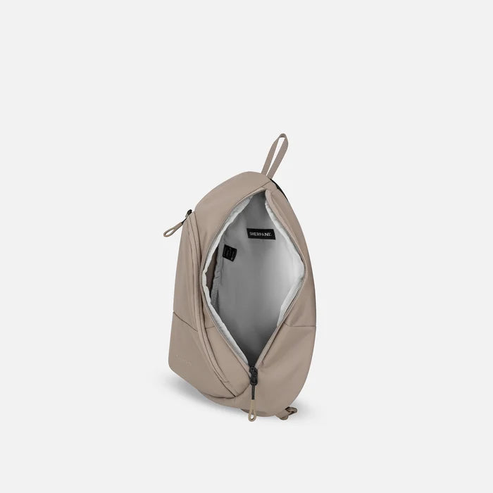 A Sherpani Wayfarer Dune Convertible Sling, above view showing inside of main pocket against white background.  #color_dune-tan