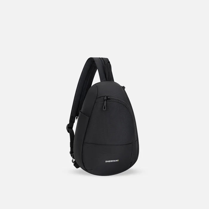 A Sherpani Wayfarer Raven Black Convertible Sling, 3/4 view showing lockable pockets and main strap on white background. #color_raven-black