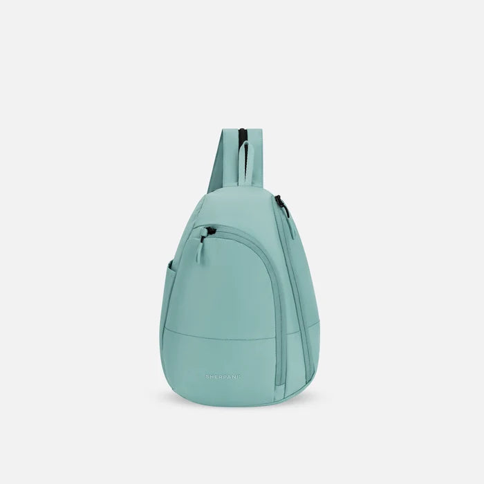 A Sherpani Wayfarer Surf Blue Convertible Sling, front view showing lockable pockets and main strap on white background. #color_surf-blue