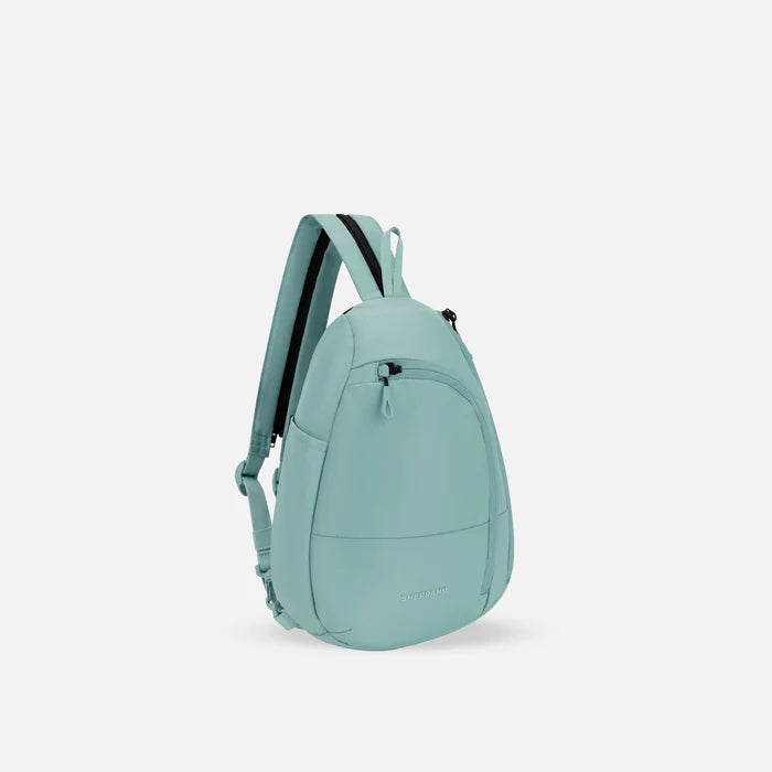 A Sherpani Wayfarer Surf Blue Convertible Sling, 3/4 view showing lockable pockets and main strap on white background. #color_surf-blue