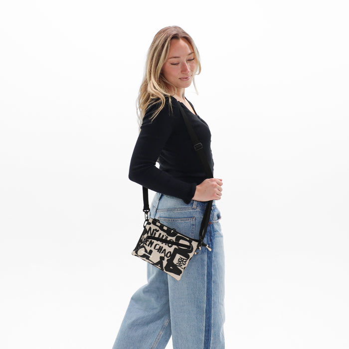 Woman wearing a Sherpani Zoom Ciao Slim RFID Crossbody against white background. #color_ciao-print