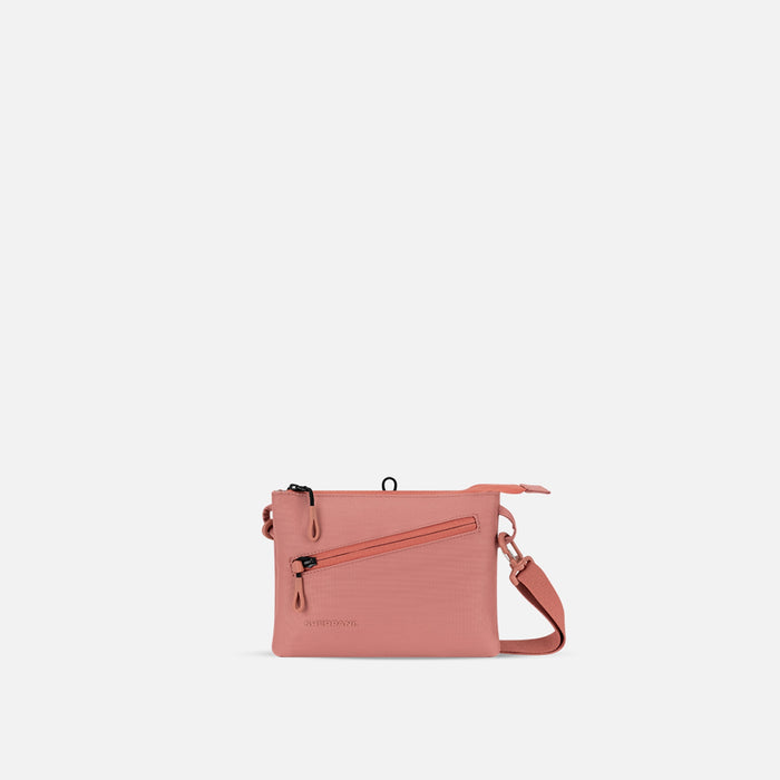 A Sherpani Zoom Desert Pink Slim RFID Crossbody, front view showing strap and pockets on white background.  #color_desert-pink