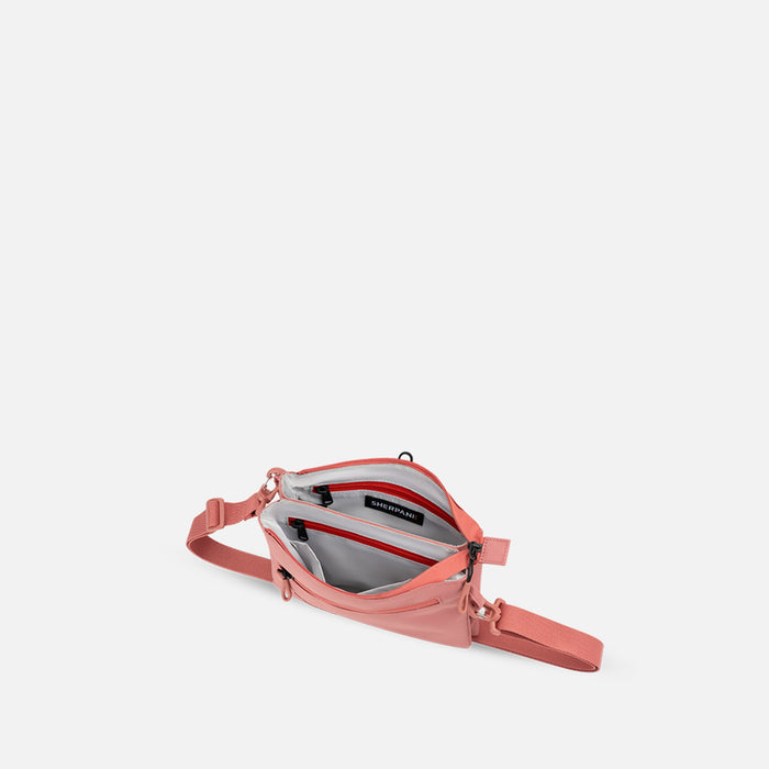 A Sherpani Zoom Desert Pink Slim RFID Crossbody, above view showing inside the two main pockets against white background.  #color_desert-pink